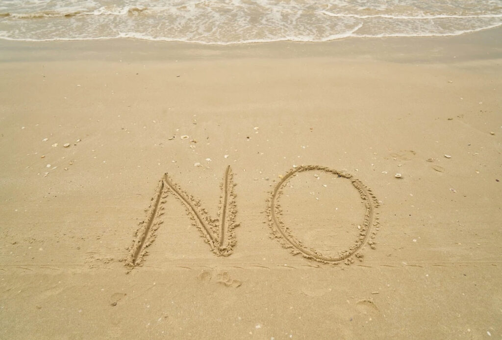 noと書かれた砂浜